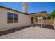 This backyard features a covered patio, gravel landscaping, and a block wall for privacy at 1408 E Carson Rd, Phoenix, AZ 85042