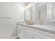 Bathroom featuring double sink vanity with granite countertop, modern fixtures, and framed mirrors at 1408 E Carson Rd, Phoenix, AZ 85042