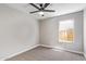 A carpeted bedroom with a ceiling fan and window providing natural light at 1408 E Carson Rd, Phoenix, AZ 85042