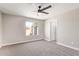 Spacious bedroom features a ceiling fan, large window, and neutral carpeting at 1408 E Carson Rd, Phoenix, AZ 85042