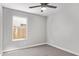 A carpeted bedroom with a ceiling fan and window providing natural light at 1408 E Carson Rd, Phoenix, AZ 85042