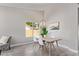 Bright dining room features modern lighting, neutral paint, wood-look tile flooring, and lots of natural light at 1408 E Carson Rd, Phoenix, AZ 85042