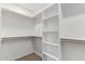 Walk-in closet featuring ample shelving and built-in wooden rods for organized storage at 1408 E Carson Rd, Phoenix, AZ 85042