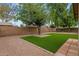 Well-maintained backyard with artificial turf lawn, mature trees, and brick border at 14215 N 36Th Way, Phoenix, AZ 85032