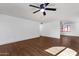 Bright living room with sleek, light-colored laminate flooring and a contemporary ceiling fan at 14215 N 36Th Way, Phoenix, AZ 85032