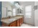 Bathroom featuring a granite countertop, wood cabinets, and a large mirror over the sink at 1425 E Commerce Ave, Gilbert, AZ 85234