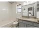 Bathroom with tiled bathtub and shower combination, granite countertop, and window at 1425 E Commerce Ave, Gilbert, AZ 85234