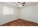 Modest bedroom with wood flooring, a ceiling fan, a window with natural light, and neutral walls at 1425 E Commerce Ave, Gilbert, AZ 85234
