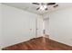 Bright bedroom with wood floors, a ceiling fan, and a view into the attached bathroom at 1425 E Commerce Ave, Gilbert, AZ 85234