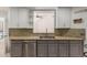 Well-lit kitchen showcasing granite countertops and stylish gray cabinetry at 1425 E Commerce Ave, Gilbert, AZ 85234