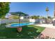 Backyard pool with blue water, green grass, brick accents and privacy wall at 1425 E Commerce Ave, Gilbert, AZ 85234