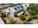 An aerial view shows solar panels, air conditioning units, and a backyard with grass, trees and a desert landscape at 1631 N Avoca --, Mesa, AZ 85207