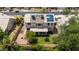 An aerial view shows solar panels, air conditioning units, and a backyard with grass, trees and a desert landscape at 1631 N Avoca --, Mesa, AZ 85207