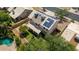 An aerial view shows solar panels, air conditioning units, and a backyard with grass, trees and a pool at 1631 N Avoca --, Mesa, AZ 85207