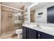 Well-lit bathroom featuring a glass shower with built-in shelf, and white sink with navy-blue vanity at 1631 N Avoca --, Mesa, AZ 85207
