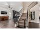 Open-concept living room with hardwood floors, featuring a staircase, a piano, and an adjacent kitchen at 1631 N Avoca --, Mesa, AZ 85207
