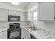 Modern kitchen featuring stainless steel appliances, marble countertops, white cabinets, and a window allowing natural light at 2220 W Dora St # 220, Mesa, AZ 85201