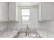 Kitchen sink with double basin, white cabinets, and a view to the world through the window at 2220 W Dora St # 220, Mesa, AZ 85201