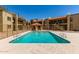 Exterior view of community pool surrounded by residential buildings and lush landscaping at 2220 W Dora St # 220, Mesa, AZ 85201