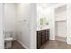 Bright bathroom with double vanity, dark wood cabinets, and a separate toilet room at 25221 N 131St Dr, Peoria, AZ 85383