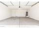 Spacious garage with concrete flooring and overhead lighting providing ample parking at 25221 N 131St Dr, Peoria, AZ 85383