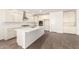 Modern kitchen featuring white cabinets, granite countertops, stainless steel appliances, and a large island at 25221 N 131St Dr, Peoria, AZ 85383