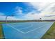 Bright blue community basketball court with lush grass surrounding, set against a cloud-filled sky at 25319 N 131St Dr, Peoria, AZ 85383