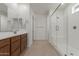 Bathroom with tile floors, wood cabinets, and a glass enclosed shower at 25319 N 131St Dr, Peoria, AZ 85383