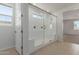 Elegant bathroom featuring a glass-enclosed shower with built-in seating and tiled floors at 25319 N 131St Dr, Peoria, AZ 85383