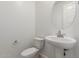 Well-lit powder room featuring a pedestal sink and round mirror at 25319 N 131St Dr, Peoria, AZ 85383
