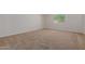 A bedroom with carpeted floors, neutral colored walls, and a single window at 25319 N 131St Dr, Peoria, AZ 85383