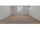 Cozy bedroom with carpet, white walls, and a window overlooking the backyard at 25319 N 131St Dr, Peoria, AZ 85383