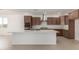 Bright kitchen with stainless appliances, white countertops, brown cabinetry, and tile flooring at 25319 N 131St Dr, Peoria, AZ 85383