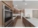 Bright kitchen with stainless appliances, white countertops, brown cabinetry, and tile flooring at 25319 N 131St Dr, Peoria, AZ 85383