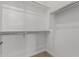 This is a walk-in closet with white walls and carpet flooring with closet rods and shelving for storage at 25319 N 131St Dr, Peoria, AZ 85383