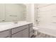 Bathroom with a tub and shower combo, modern sink, gray cabinets, and wood-style flooring at 25324 N 131St Dr, Peoria, AZ 85383