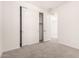 Neutral bedroom with a sliding door closet, carpet floors, and a hallway to additional rooms at 25324 N 131St Dr, Peoria, AZ 85383