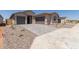Attractive home featuring a three car garage, paved driveway, neutral-toned exterior, and landscaped front yard at 25324 N 131St Dr, Peoria, AZ 85383