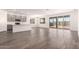 Open-concept living area featuring stylish wood-look tile flooring and natural light at 25324 N 131St Dr, Peoria, AZ 85383