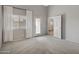 A bright bedroom has light grey walls, neutral carpet, and large windows with sheer curtains allowing light to filter through at 2629 E Hidalgo Ave, Phoenix, AZ 85040
