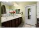 Bathroom with a double sink vanity, a large mirror and flowers at 26456 W Cat Balue Dr, Buckeye, AZ 85396