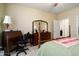Bedroom with a four poster bed and a wooden desk with lamp at 26456 W Cat Balue Dr, Buckeye, AZ 85396