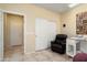 Bedroom featuring a recliner, desk space and convenient closet access at 26456 W Cat Balue Dr, Buckeye, AZ 85396