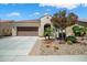 Attractive house showcasing well-maintained landscaping with colorful flowering plants and a wide concrete driveway at 26456 W Cat Balue Dr, Buckeye, AZ 85396