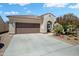 Charming home featuring a tile roof, desert landscaping, and a spacious driveway leading to a two-car garage at 26456 W Cat Balue Dr, Buckeye, AZ 85396