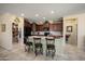 Well-lit kitchen with dark wood cabinets, stainless steel appliances, large center island, and tile flooring at 26456 W Cat Balue Dr, Buckeye, AZ 85396