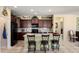Spacious kitchen featuring a central island, dark cabinets, modern appliances, and bar stool seating at 26456 W Cat Balue Dr, Buckeye, AZ 85396