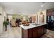 Open concept kitchen with island and breakfast bar seamlessly connecting to the living room area at 26456 W Cat Balue Dr, Buckeye, AZ 85396