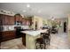 Bright kitchen with granite countertops, dark cabinetry, eat-in island, and adjacent dining area at 26456 W Cat Balue Dr, Buckeye, AZ 85396