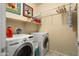 Laundry room with front load washer and dryer and overhead shelf space at 26456 W Cat Balue Dr, Buckeye, AZ 85396